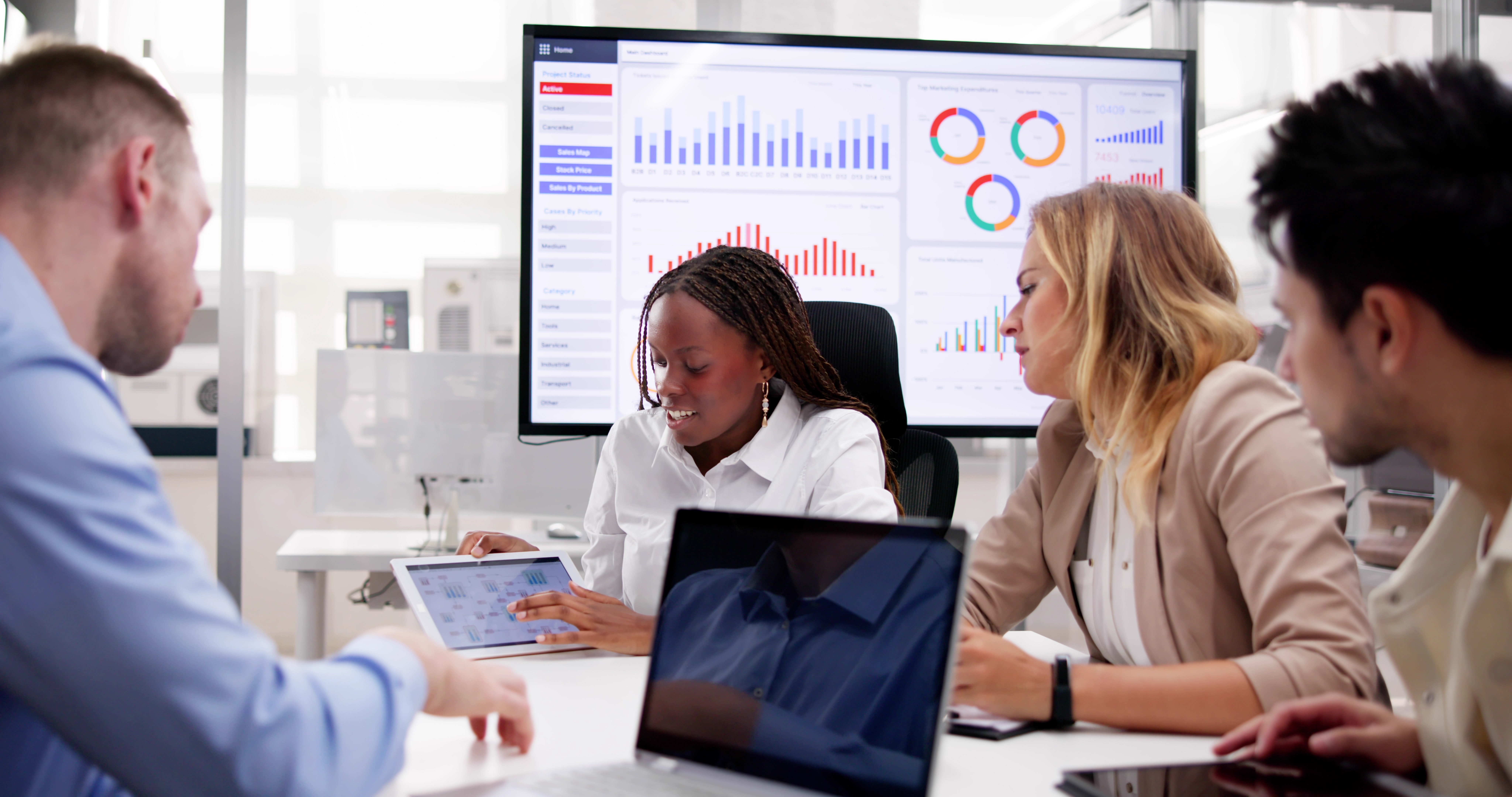 AI leadership in manufacturing reviewing digital dashboards in a modern office and collaborating on data strategy.